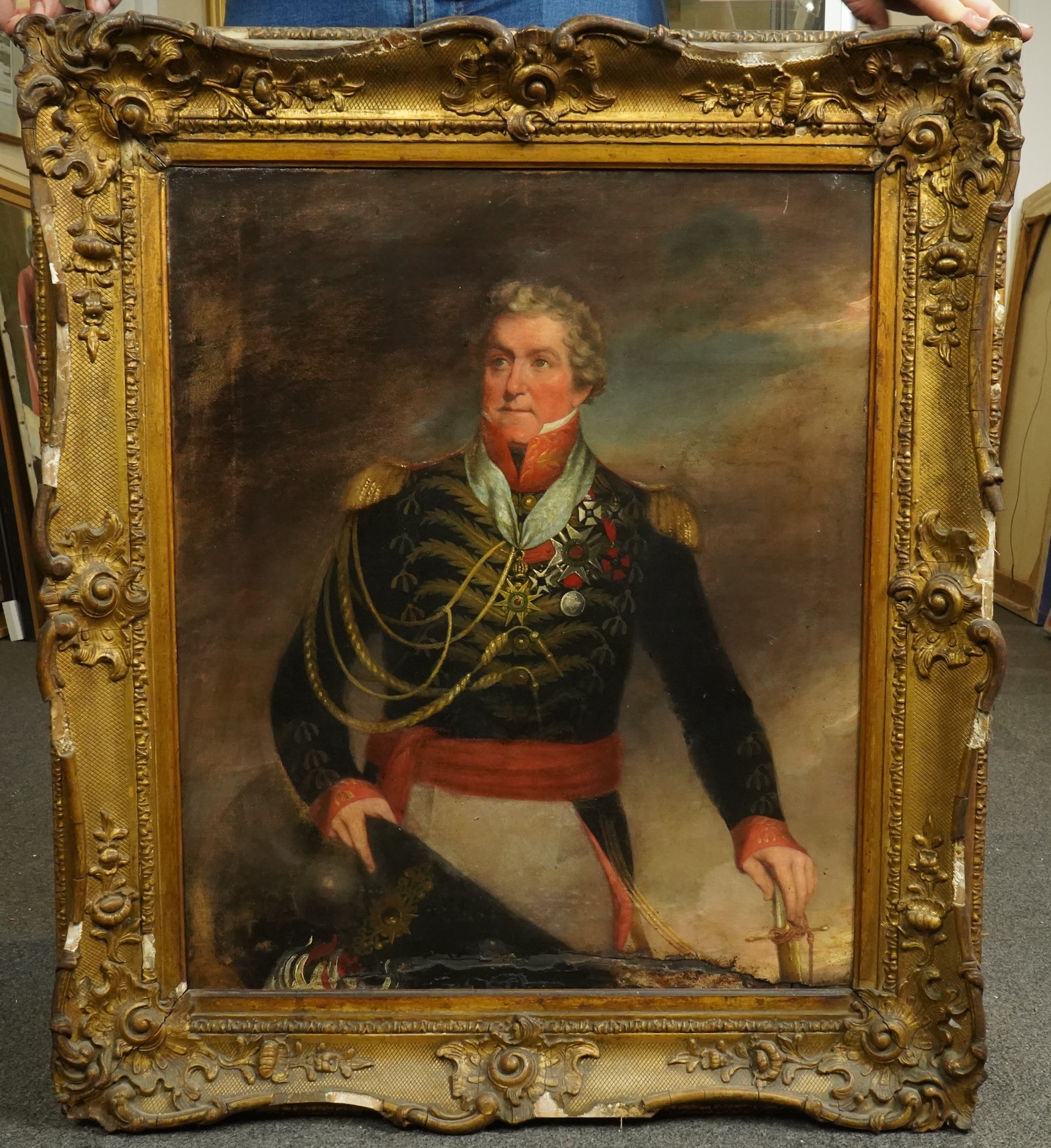 Early 19th Century English School, Three quarter length portrait of a Napoleonic General, standing with hat and sword in hand, clouds beyond, oil on canvas, 59 x 49cm